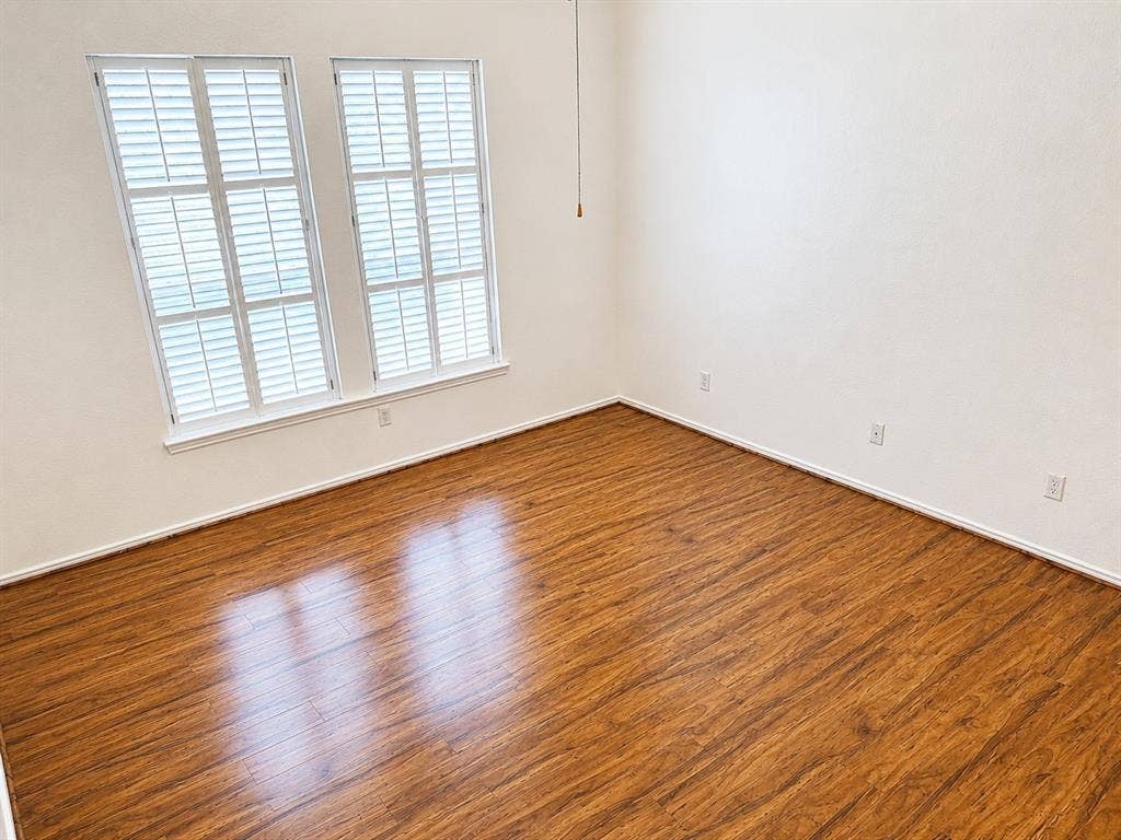 103 Denali Court, Terrell, TX 75160 Spacious primary bedroom featuring wood-finish flooring, white baseboards, and bright white walls