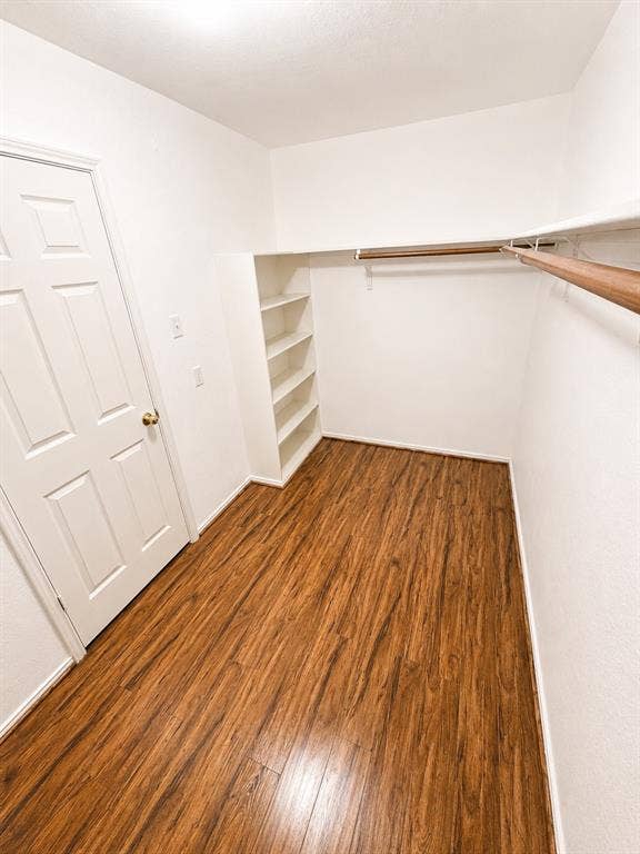 103 Denali Court, Terrell, TX 75160 Walk-in closet featuring wood-finish flooring, built-in shelving, and dual clothes rods