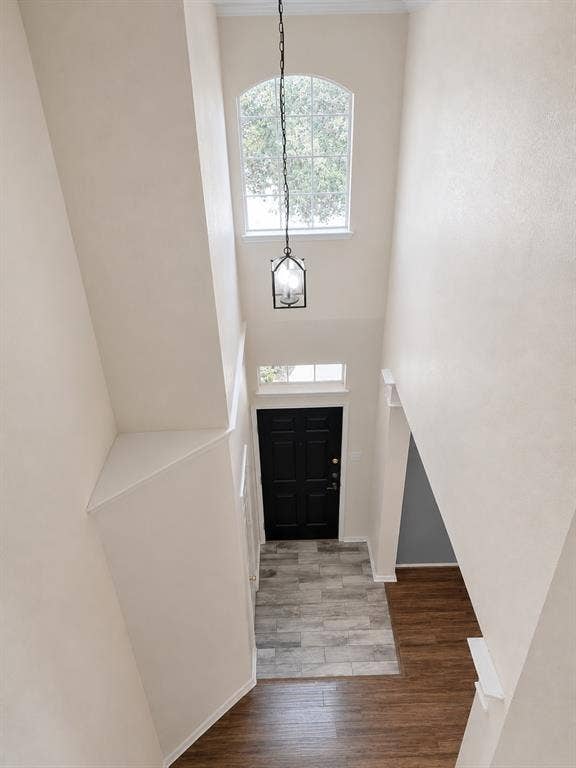 103 Denali Court, Terrell, TX 75160 Two-story foyer featuring an arched window, a black lantern-style pendant light, a dark paneled entry door, and wood-finish flooring with a tile entryway