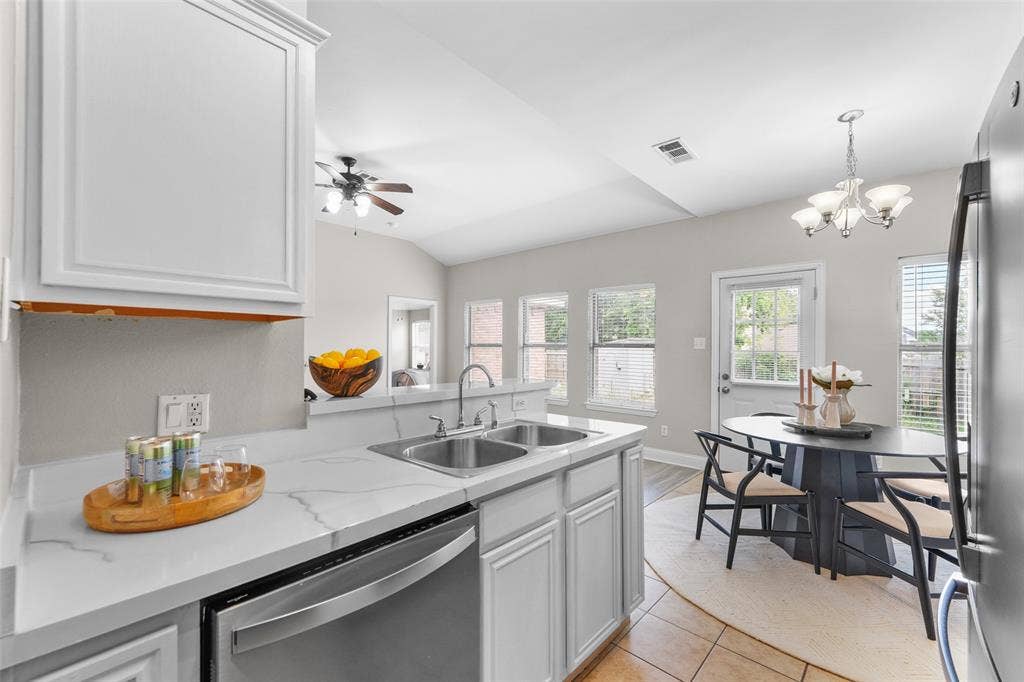 2408 Castle Ridge Drive, McKinney, TX 75071 Kitchen featuring stainless steel appliances, white cabinets, hanging lights, ceiling fan, and a peninsula