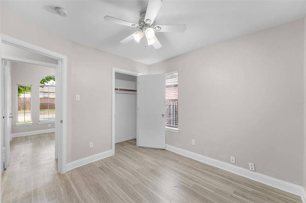 2408 Castle Ridge Drive, McKinney, TX 75071 Unfurnished bedroom featuring light wood-style flooring, a ceiling fan, and a closet