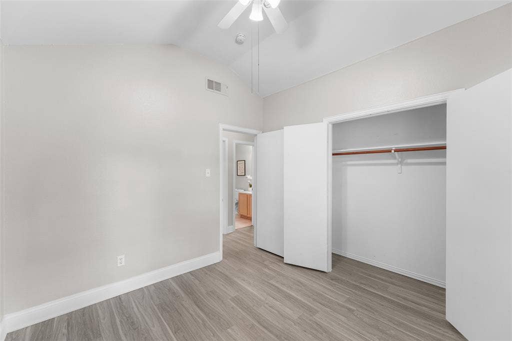 2408 Castle Ridge Drive, McKinney, TX 75071 Unfurnished bedroom featuring vaulted ceiling, light wood finished floors, a closet, and ceiling fan