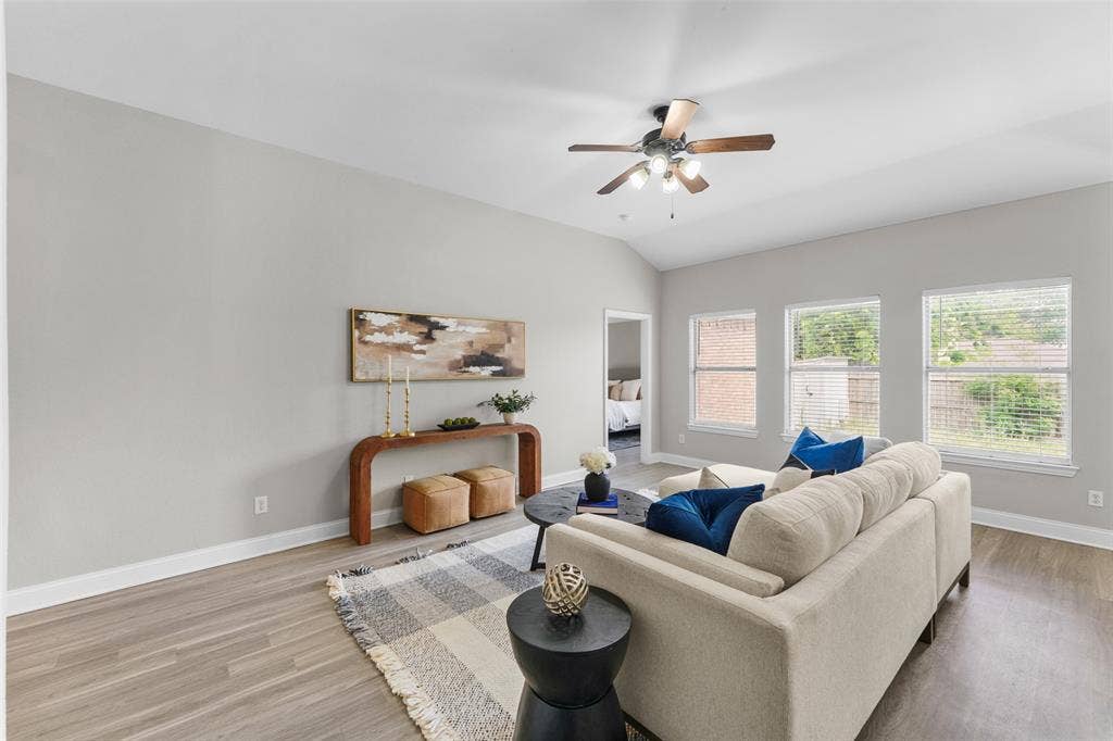 2408 Castle Ridge Drive, McKinney, TX 75071 Virtually staged. Living room featuring a ceiling fan, light wood-type flooring, and vaulted ceiling