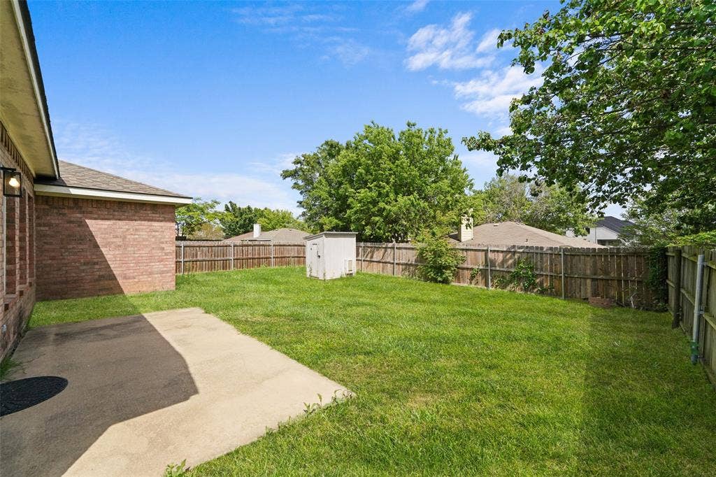 2408 Castle Ridge Drive, McKinney, TX 75071 Fenced backyard featuring a storage shed and a patio area