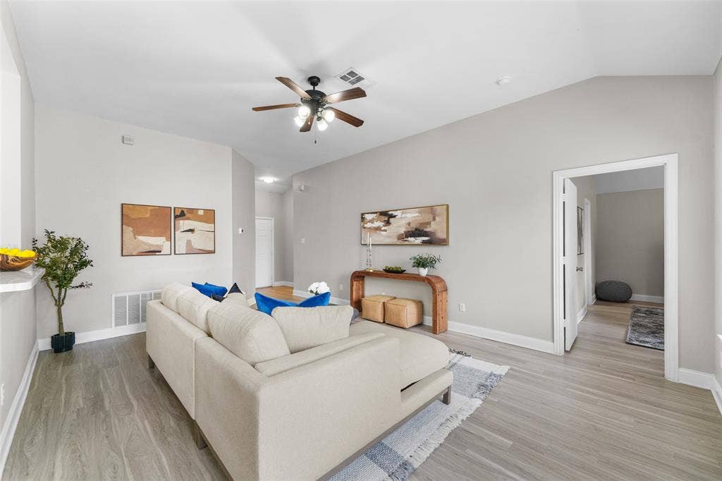 2408 Castle Ridge Drive, McKinney, TX 75071 Virtually staged. Living room featuring ceiling fan, light wood-style floors, and vaulted ceiling