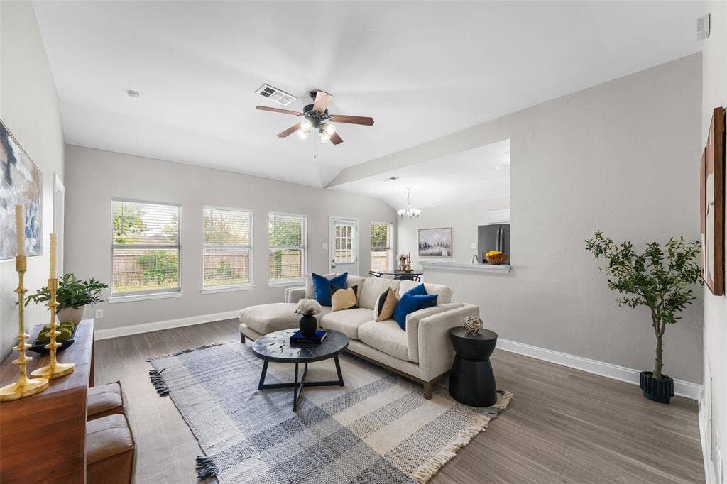 2408 Castle Ridge Drive, McKinney, TX 75071 Virutally staged. Living area with ceiling fan, healthy amount of natural light, wood finished floors, and lofted ceiling