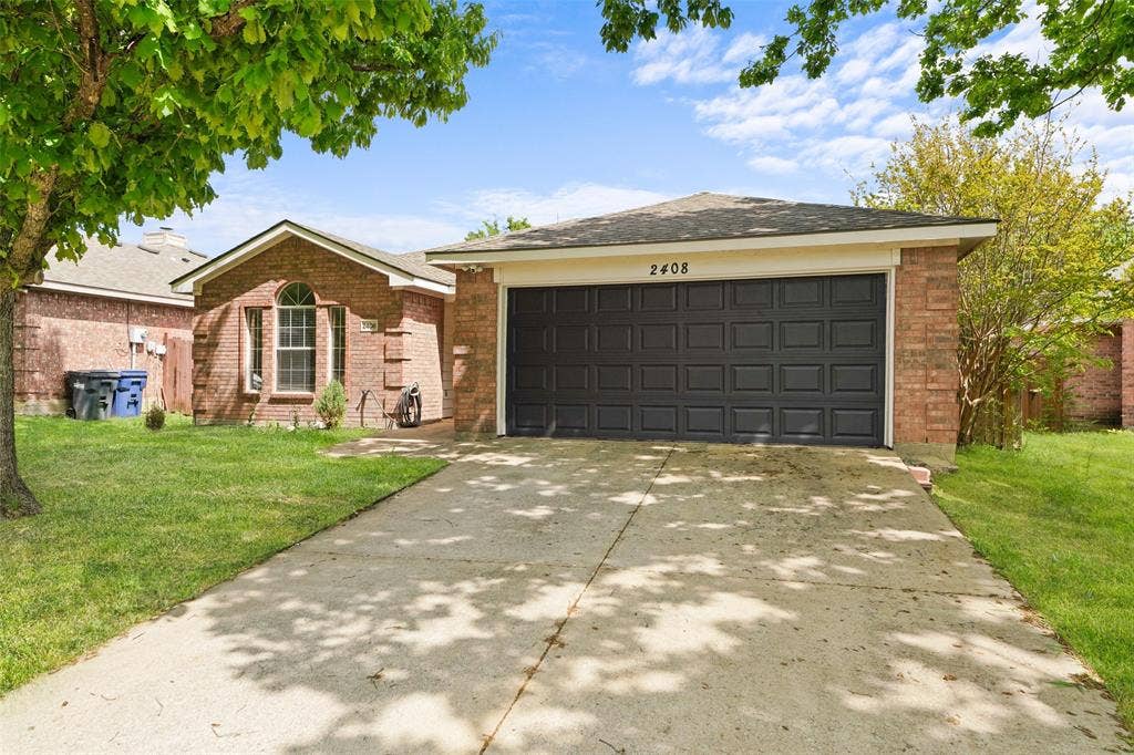 2408 Castle Ridge Drive, McKinney, TX 75071 Single story home featuring a front yard, brick siding, driveway, and an attached garage