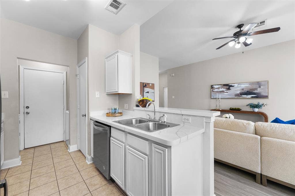 2408 Castle Ridge Drive, McKinney, TX 75071 Kitchen featuring open floor plan, light countertops, white cabinets, stainless steel dishwasher, and ceiling fan