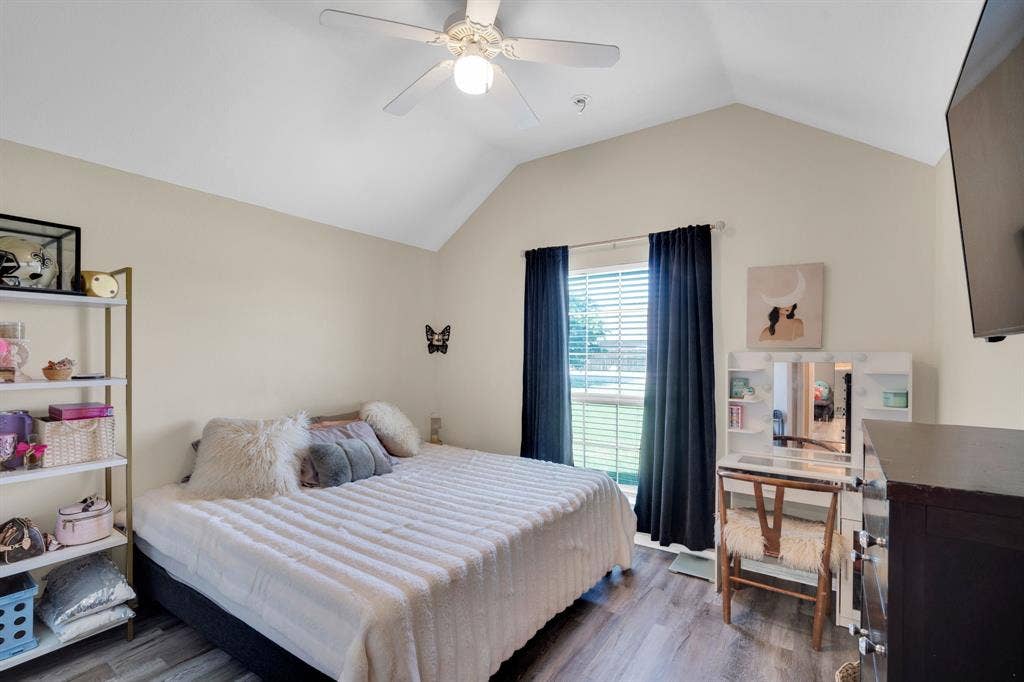 160 Berkshire Lane, Waxahachie, TX 75165 Vaulted ceiling bedroom featuring wood-finish flooring, a ceiling fan with integrated lighting, and a window with blinds