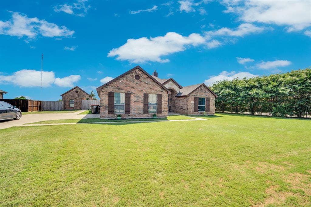 160 Berkshire Lane, Waxahachie, TX 75165 Brick exterior featuring dark brown window shutters and a gabled roofline