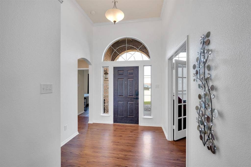 160 Berkshire Lane, Waxahachie, TX 75165 Entryway featuring a dark wood-finish door with sidelights, an arched transom window, and wood-finish flooring