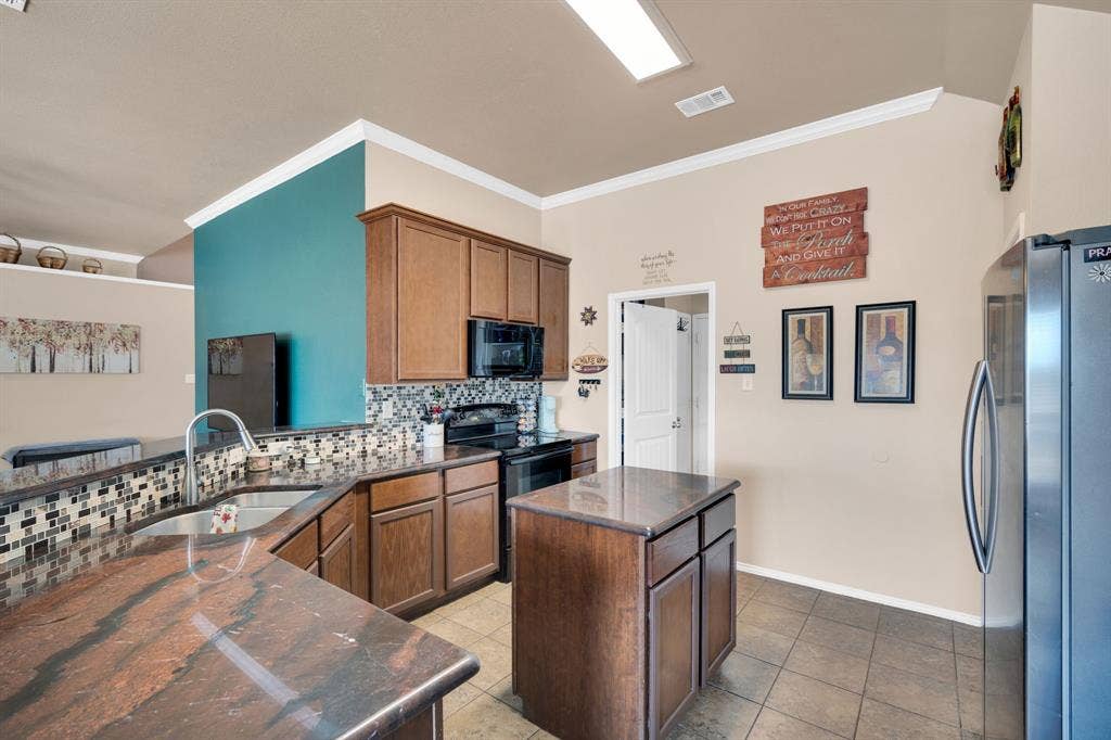 160 Berkshire Lane, Waxahachie, TX 75165 Kitchen featuring black appliances, backsplash, a peninsula, a center island, and dark countertops