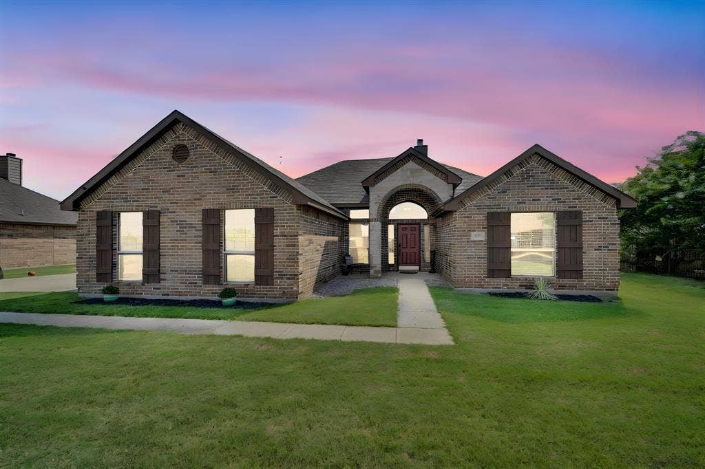 160 Berkshire Lane, Waxahachie, TX 75165 Brick exterior with gabled rooflines, decorative shutters, arched entryway, and a concrete walkway