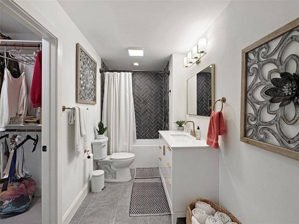 4401 Clarke Drive, Fort Worth, TX 76135 Bathroom featuring vanity, a spacious closet, shower / bath combo with shower curtain, and light tile patterned flooring
