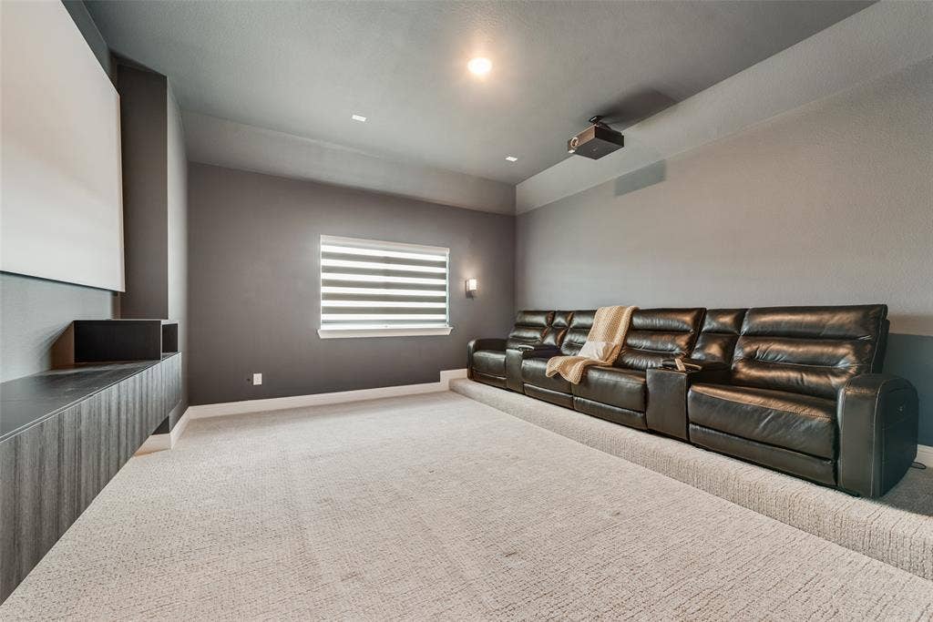 7108 Woodside Drive, Argyle, TX 76226 Media room with rised seat, cabinet, screen, surrounding sound system and laser projector