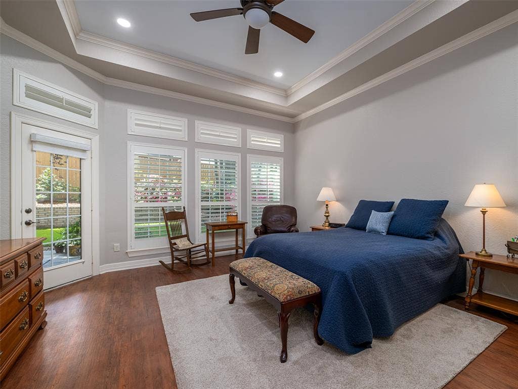 1137 Ashwood Drive, Tyler, TX 75703 Primary bedroom with tray ceiling, and a view of the gorgeous azalea bushes with a door outside to the patio.