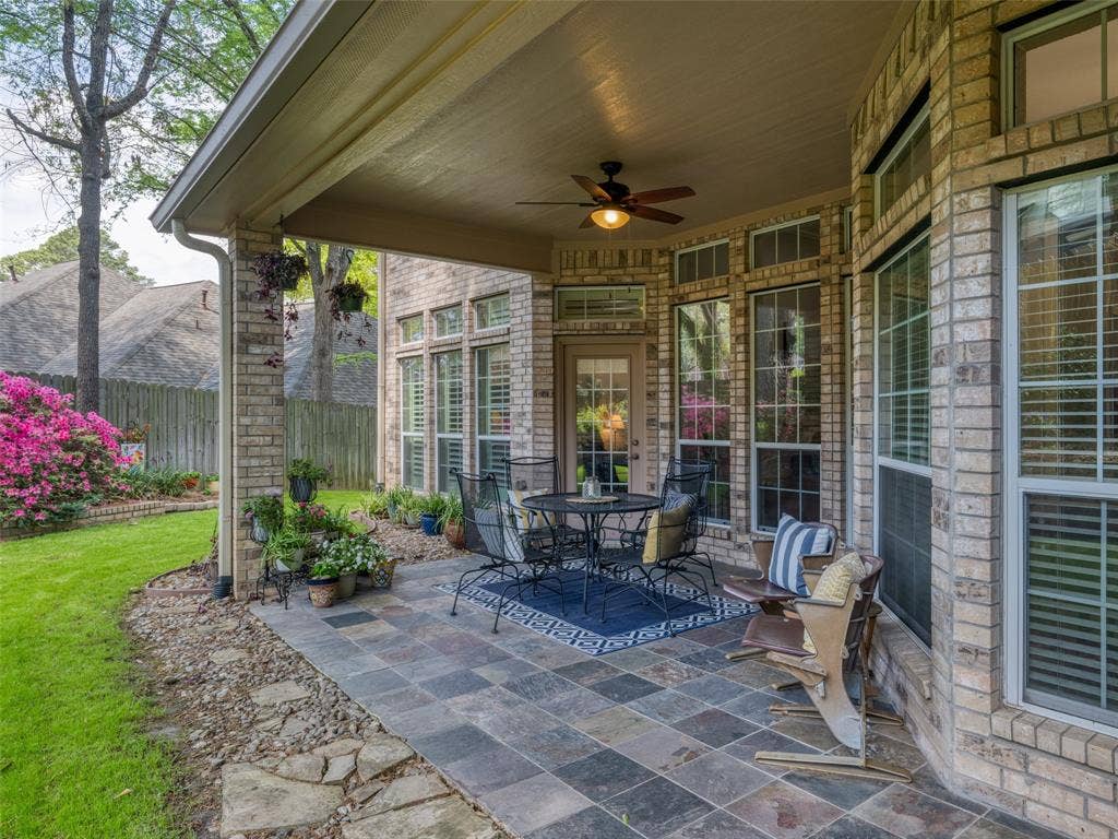 1137 Ashwood Drive, Tyler, TX 75703 Beautiful covered back porch with stone and tile, and a lighted ceiling fan to sit under to enjoy the flora and fauna.