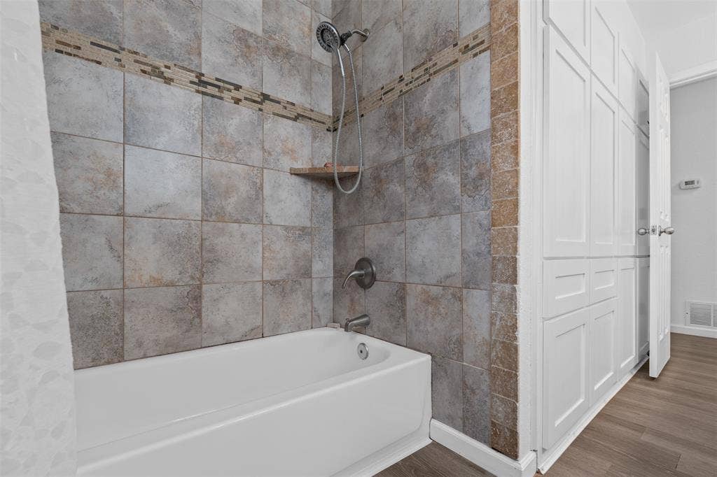 1819 W Cedar Elm Drive, Arlington, TX 76012 Hall bathroom has this lovely tile shower & tons of extra storage cabinets!