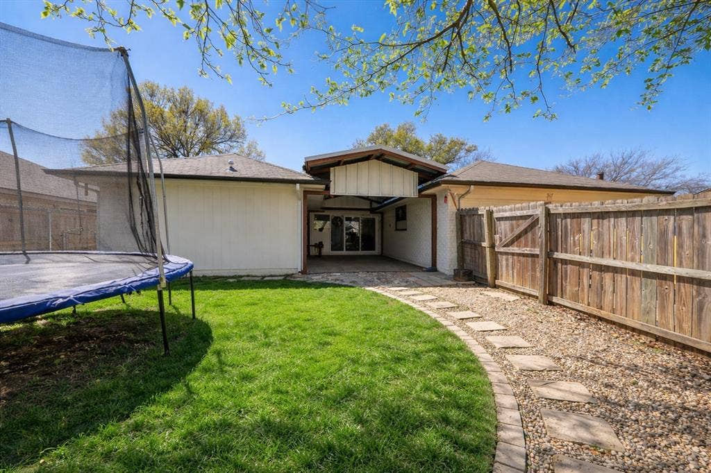 317 Stillmeadow Drive, Garland, TX 75040 A seamless extension of the home, the covered patio creates a comfortable outdoor living area—ideal for morning coffee, evening conversations, or weekend get-togethers. The defined pathway and green space bring both function and charm to the backyard setting.