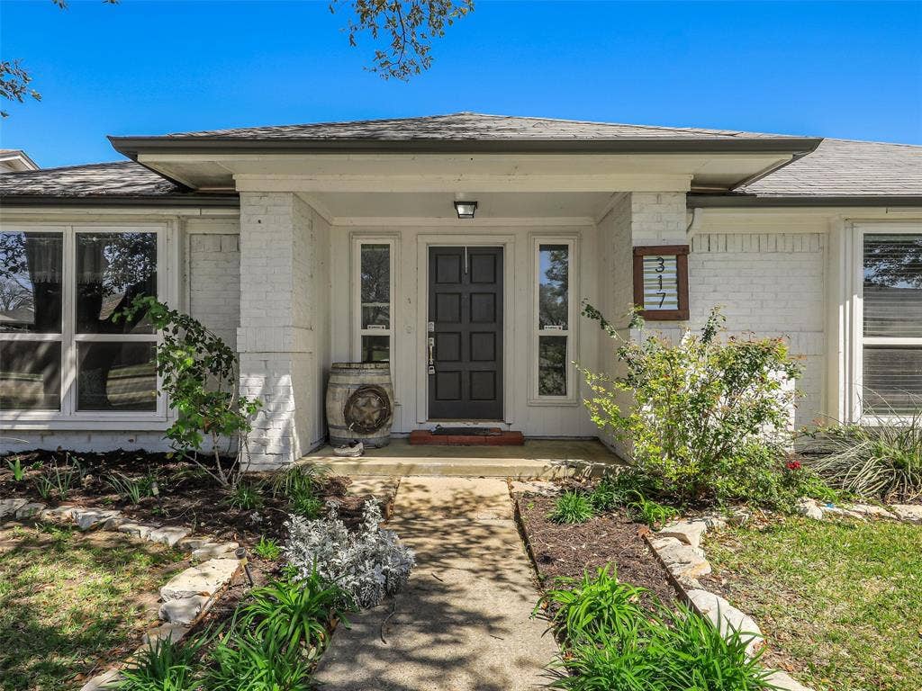 317 Stillmeadow Drive, Garland, TX 75040 Step into a covered front porch framed by classic brickwork and clean landscaping. This inviting entry offers a comfortable transition into the home with space to personalize and make your own.