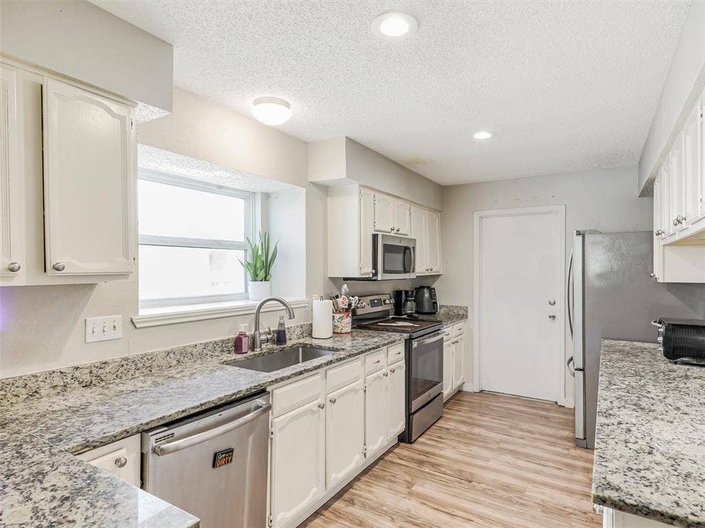 317 Stillmeadow Drive, Garland, TX 75040 Bright, clean, and functional—the kitchen offers plenty of room to cook, prep, and gather. Granite countertops and stainless appliances bring a polished feel, while the layout keeps everything within reach.