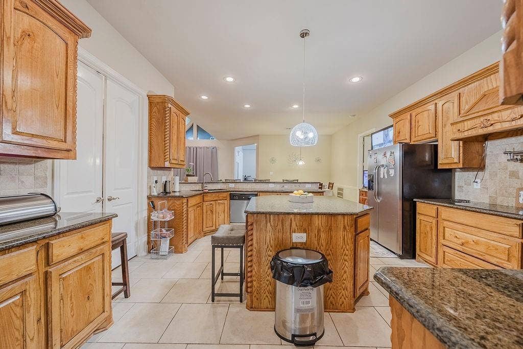 1011 Parview Circle, Grand Prairie, TX 75104 Kitchen featuring tasteful backsplash, a peninsula, granite counters, and a kitchen island