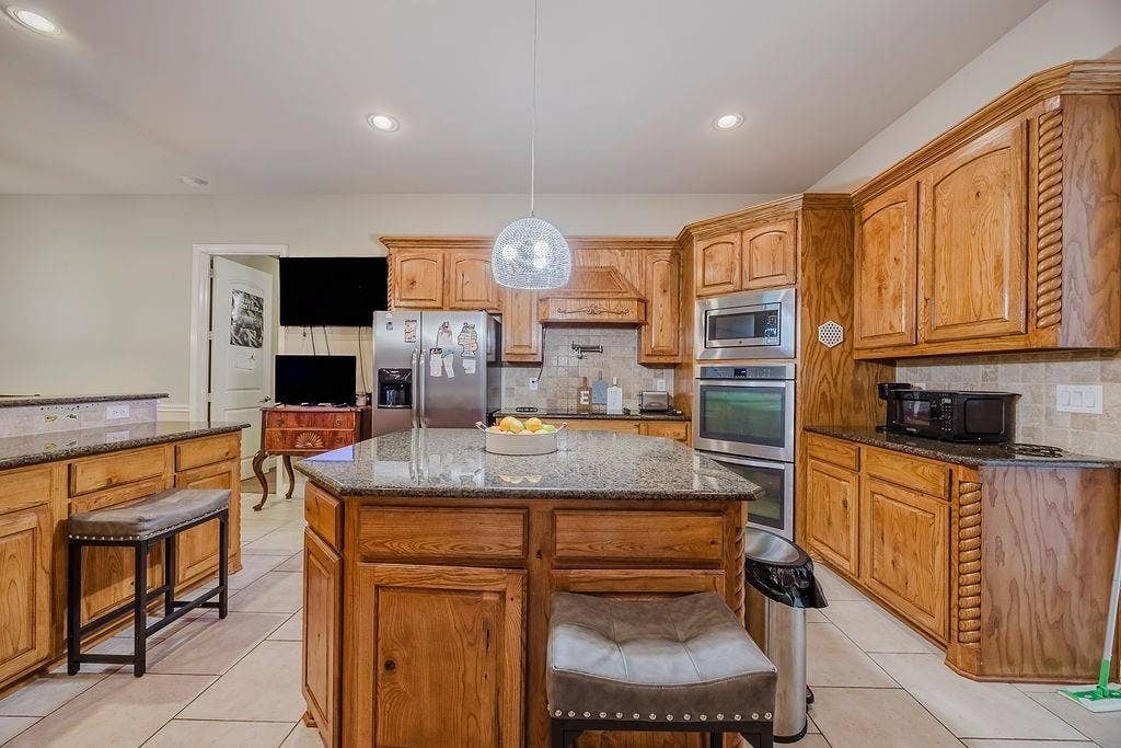 1011 Parview Circle, Grand Prairie, TX 75104 Kitchen with granite countertops, a center island, stainless steel appliances, backsplash, and decorative light fixtures
