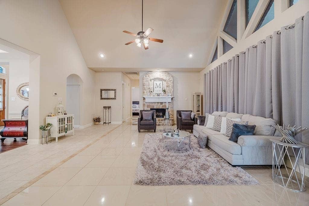 1011 Parview Circle, Grand Prairie, TX 75104 Living room with light tile patterned floors, a ceiling fan, a stone fireplace, recessed lighting, and vaulted ceiling