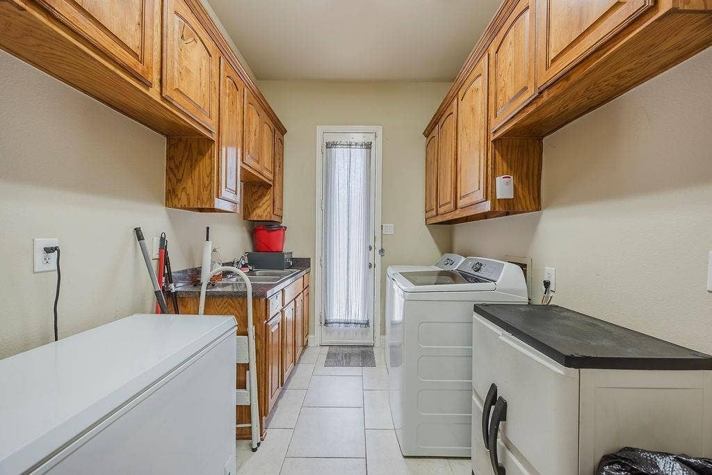 1011 Parview Circle, Grand Prairie, TX 75104 Laundry area with cabinet space, washing machine and dryer, and light tile patterned floors