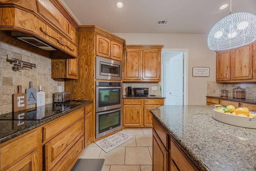 1011 Parview Circle, Grand Prairie, TX 75104 Kitchen with backsplash, granite countertops, and wood finish cabinetry