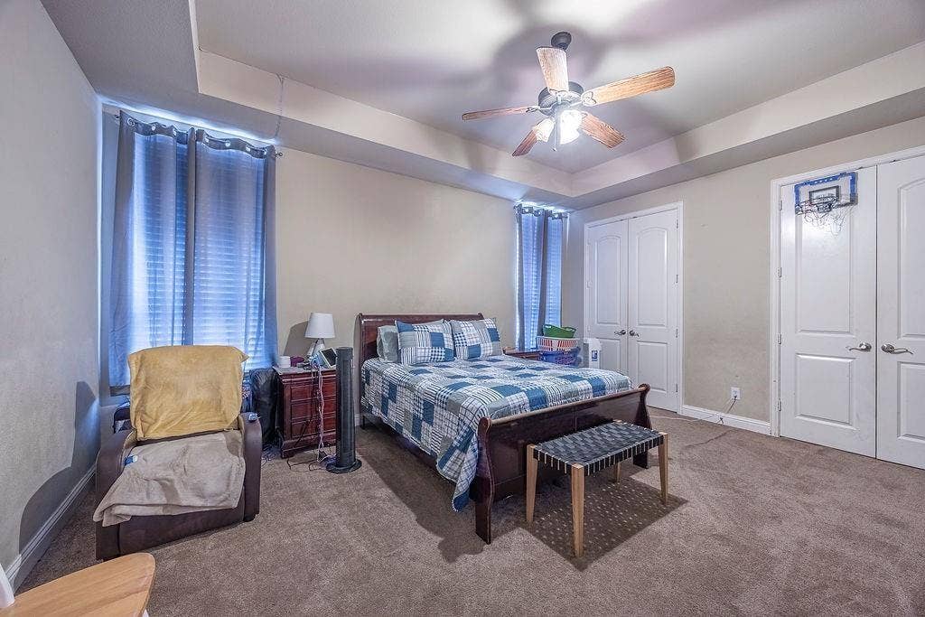 1011 Parview Circle, Grand Prairie, TX 75104 Carpeted bedroom featuring a tray ceiling, two closets, and ceiling fan