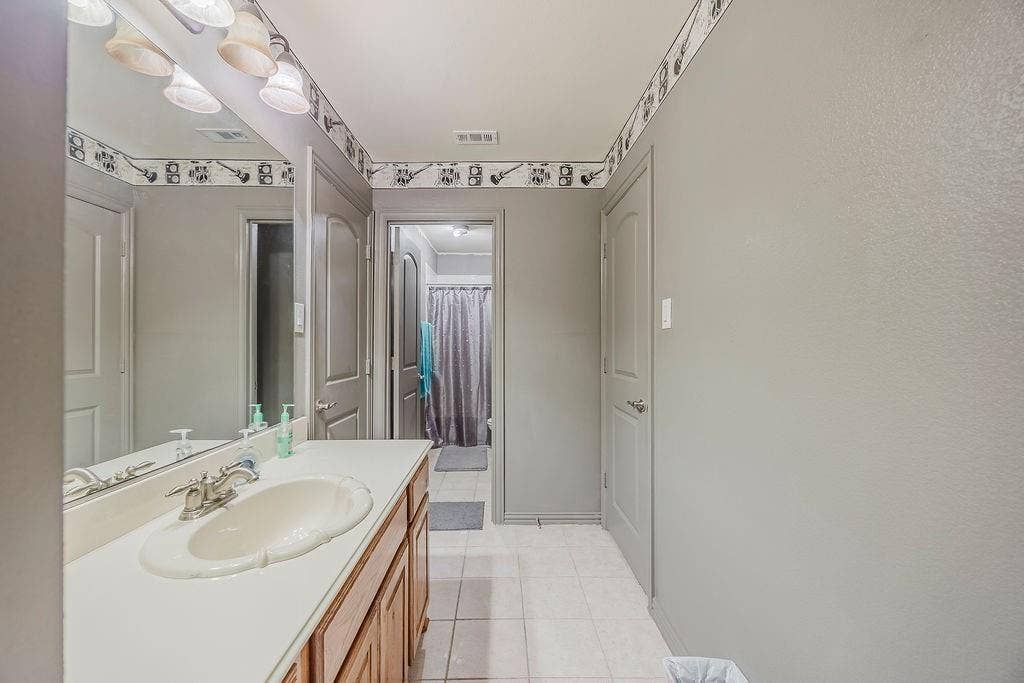 1011 Parview Circle, Grand Prairie, TX 75104 Bathroom featuring vanity, curtained shower, and light tile patterned floors