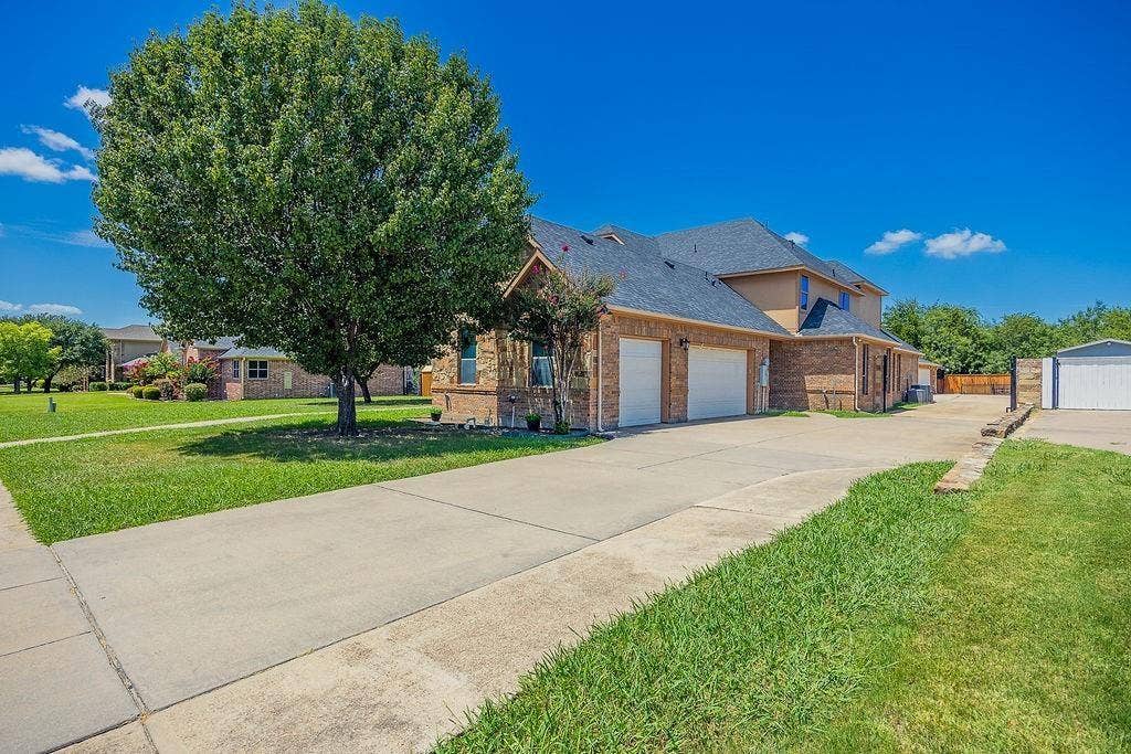 1011 Parview Circle, Grand Prairie, TX 75104 View of front of house featuring a front lawn, concrete driveway, a garage, and brick siding