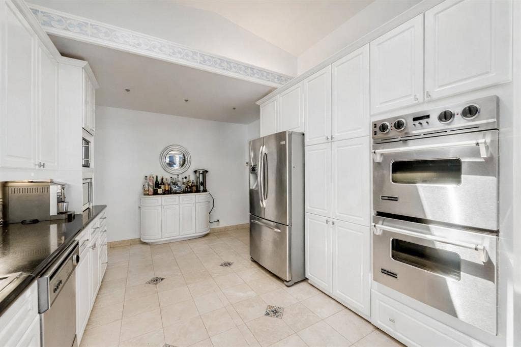This is a rendering if the kitchen cabinets were to be painted white from the current blue.