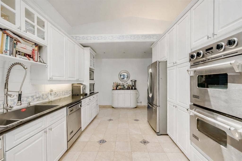This is a rendering if the kitchen cabinets were to be painted white from the current blue.