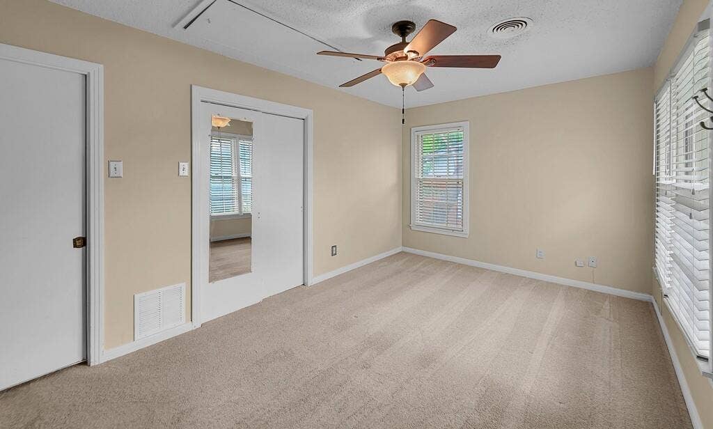 3917 Morrow Avenue, Waco, TX 76710 Unfurnished bedroom with light colored carpet, ceiling fan, and a textured ceiling