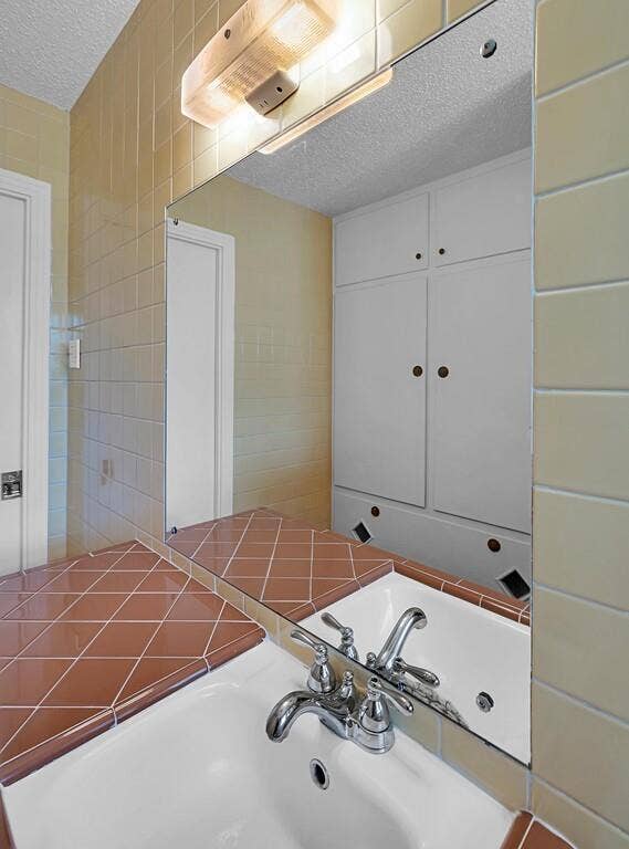 3917 Morrow Avenue, Waco, TX 76710 Bathroom with a textured ceiling and tile walls