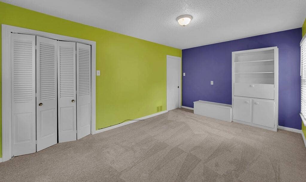 3917 Morrow Avenue, Waco, TX 76710 Unfurnished bedroom featuring a closet, light colored carpet, and a textured ceiling