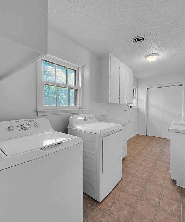 3917 Morrow Avenue, Waco, TX 76710 Laundry room with a textured ceiling, healthy amount of natural light, washing machine and clothes dryer, and cabinet space