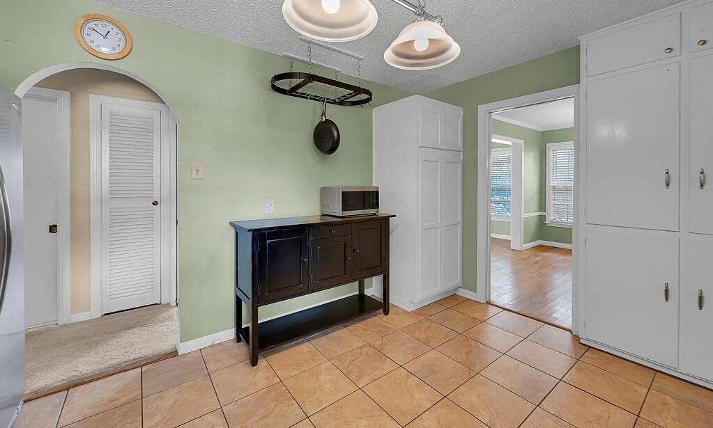 3917 Morrow Avenue, Waco, TX 76710 Hallway featuring light tile patterned floors, a textured ceiling, and arched walkways