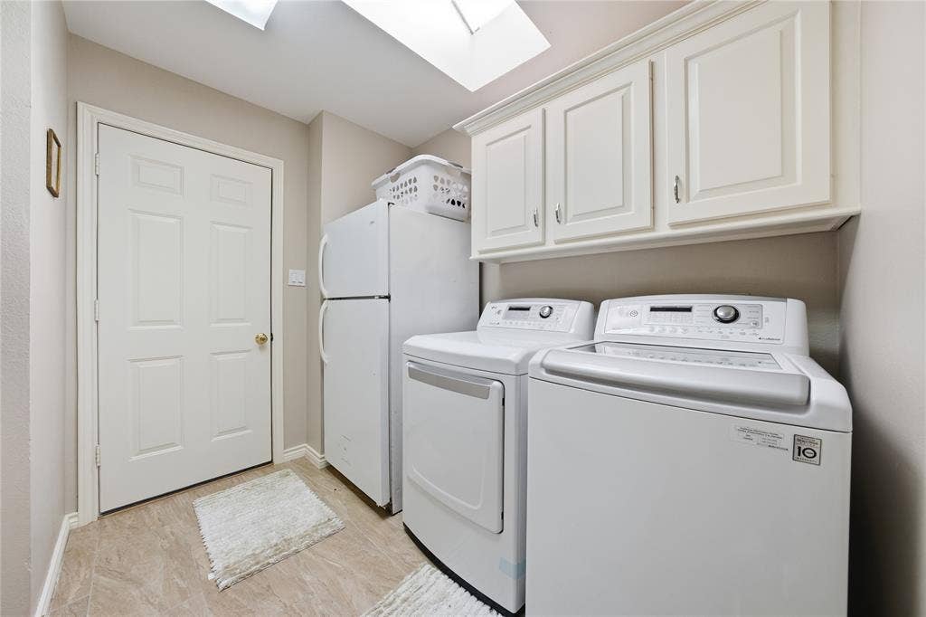 820 Torribrooke Lane, Athens, TX 75751 Laundry area featuring a skylight, washing machine and clothes dryer, and cabinet space