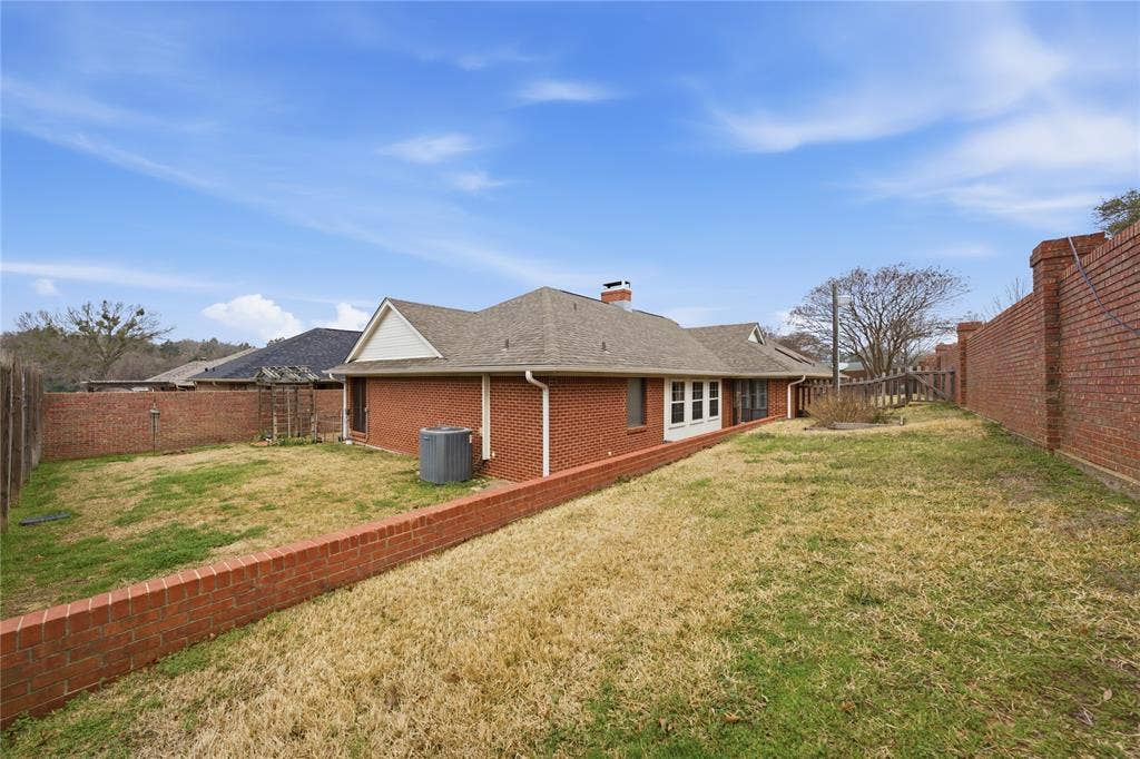 820 Torribrooke Lane, Athens, TX 75751 Back of property with brick siding, a fenced backyard, a chimney, and roof with shingles