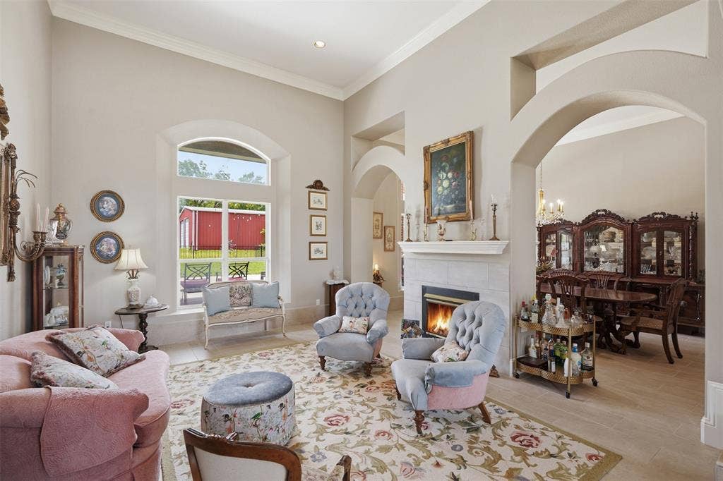 451 Land Of Goshen Drive, Springtown, TX 76082 Spacious living area featuring a fireplace with a light-toned tile surround, arched architectural details, high vaulted ceilings, large windows, and tile flooring