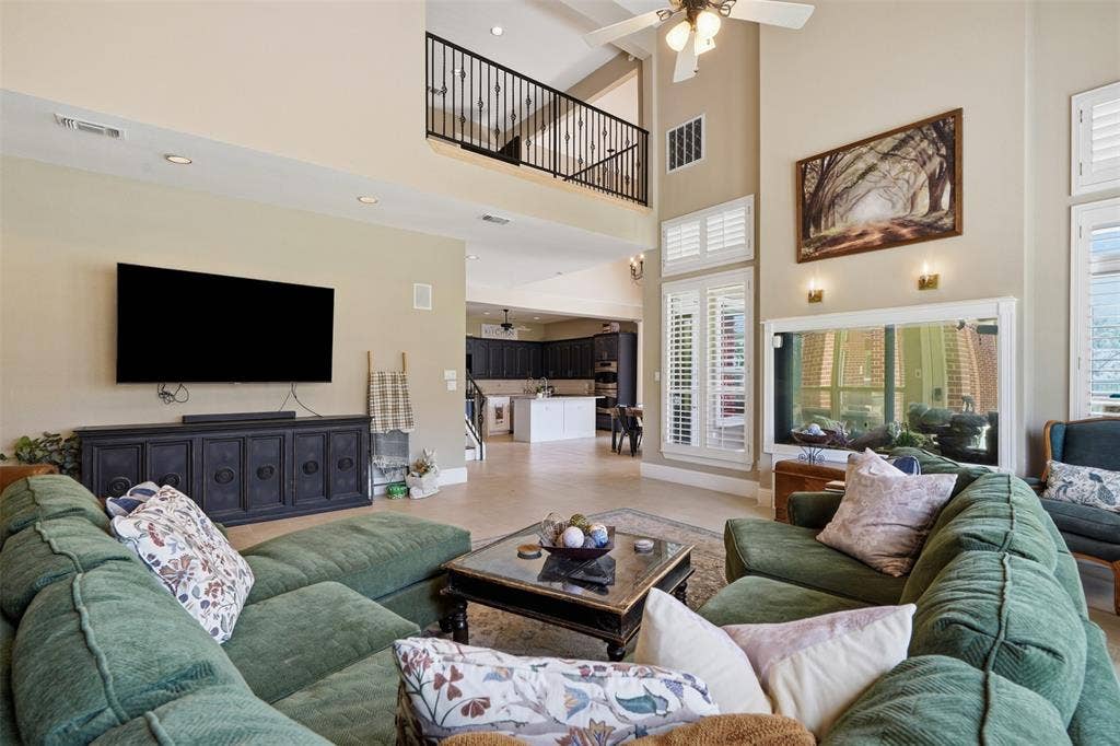 451 Land Of Goshen Drive, Springtown, TX 76082 Two-story living area featuring a vaulted ceiling and an upper-level balcony with iron balusters