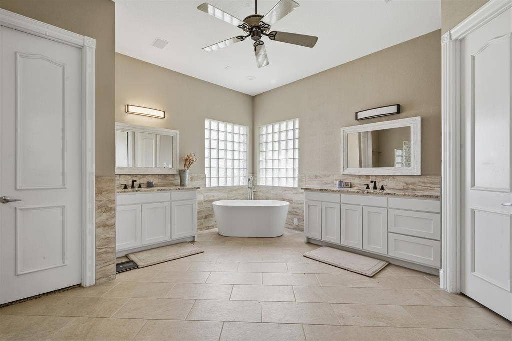 451 Land Of Goshen Drive, Springtown, TX 76082 Spacious bathroom featuring a freestanding tub, dual vanity with shaker cabinets, tile flooring, and glass block windows