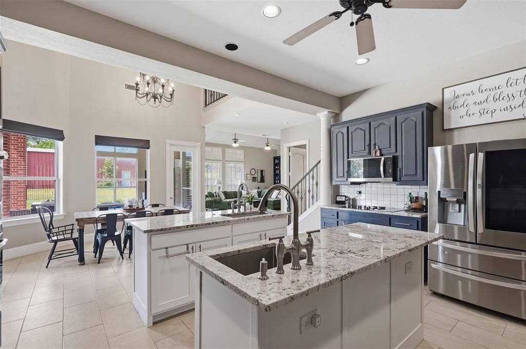 451 Land Of Goshen Drive, Springtown, TX 76082 Open-concept kitchen with dual islands featuring granite countertops, a stainless steel sink, and a high-arch faucet