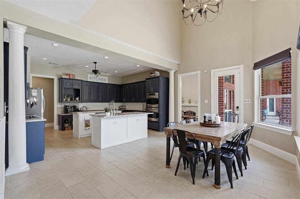451 Land Of Goshen Drive, Springtown, TX 76082 Spacious kitchen and dining area featuring high ceilings, light-toned tile flooring, and dark cabinetry
