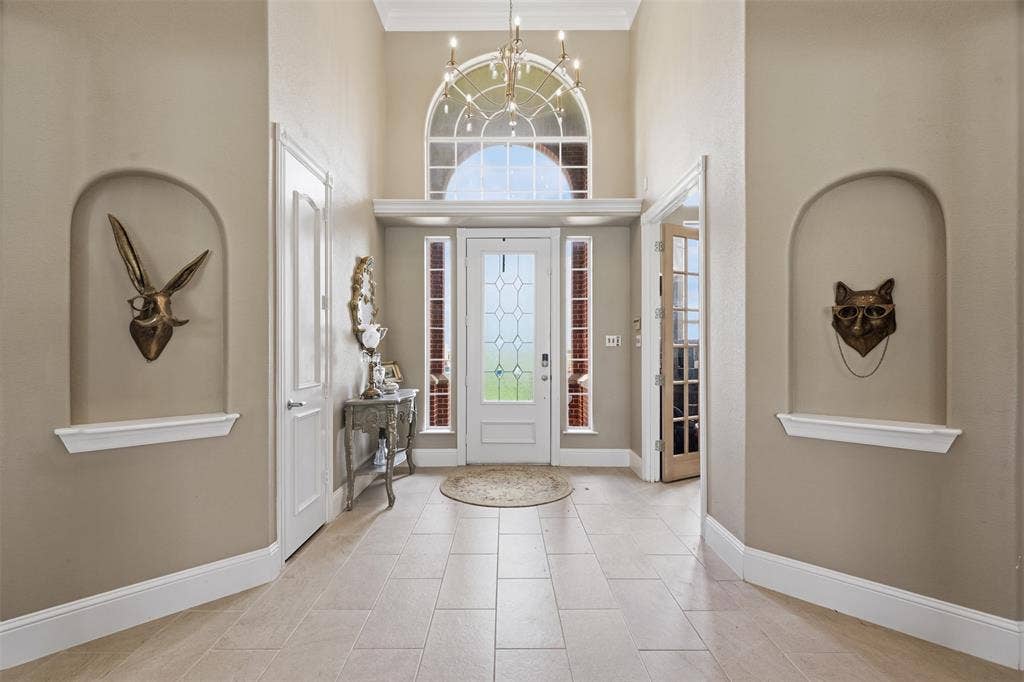 451 Land Of Goshen Drive, Springtown, TX 76082 Two-story foyer featuring large format tile flooring and arched wall niches with display ledges