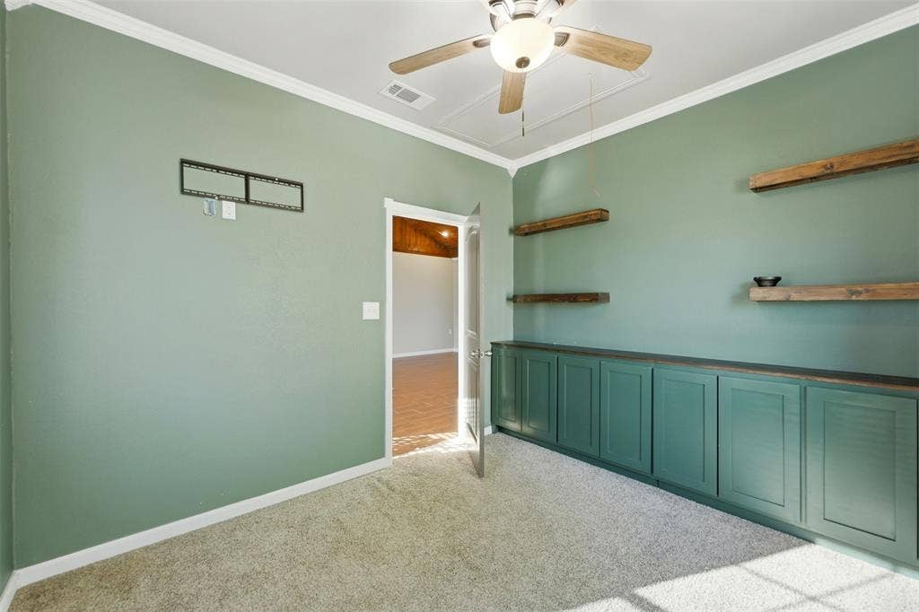 113 Mulkey Road, Waxahachie, TX 75167 Spare room featuring light carpet, ornamental molding, and ceiling fan