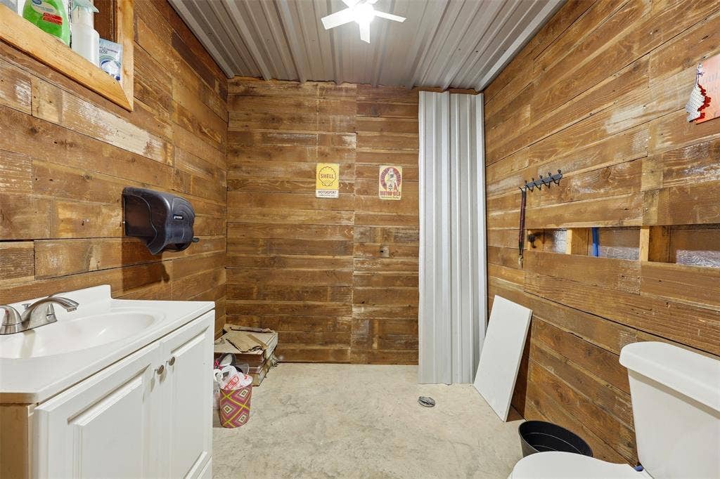 113 Mulkey Road, Waxahachie, TX 75167 Bathroom featuring wooden walls, vanity, and concrete flooring